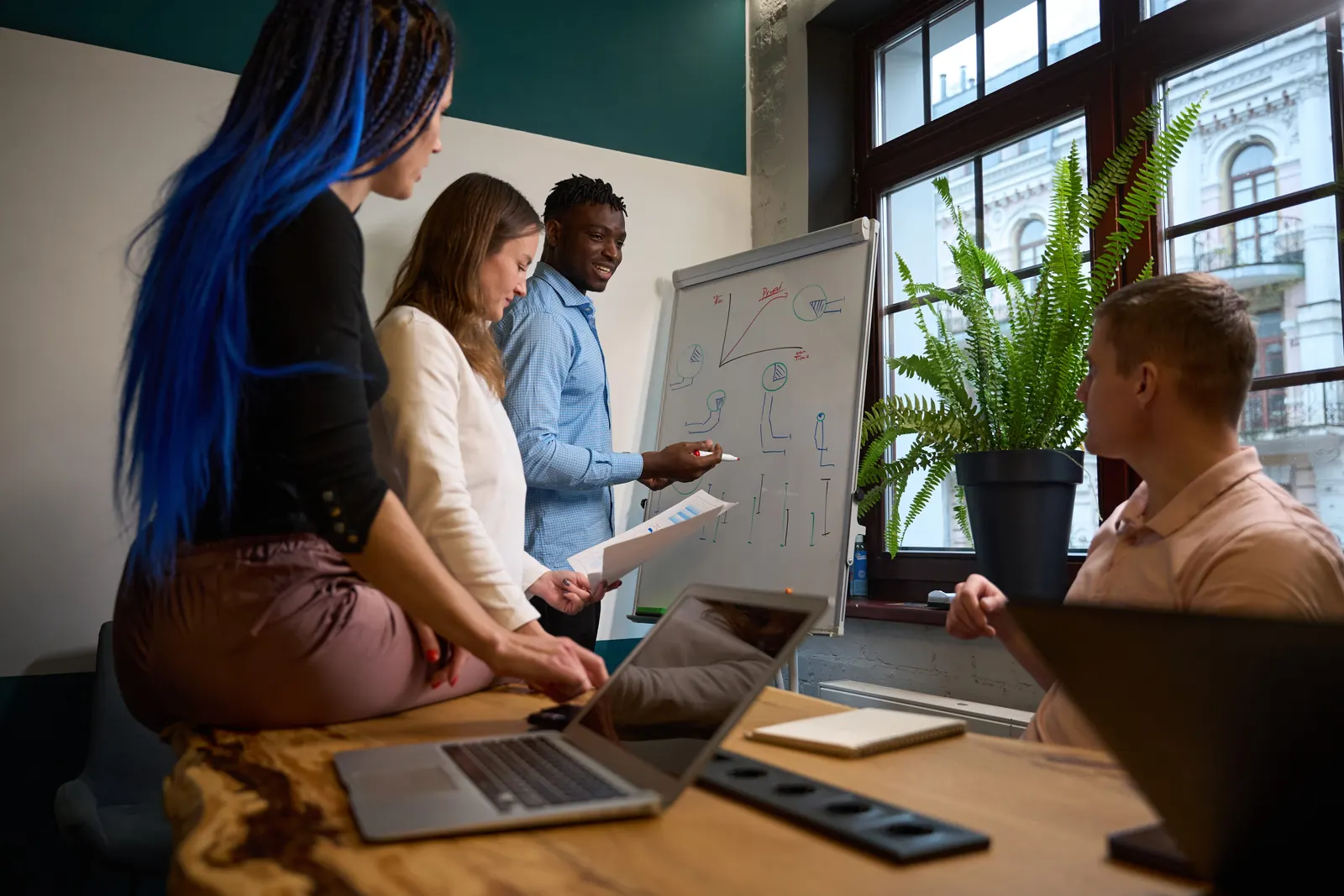 A cross-functional team working through a problem on a whiteboard